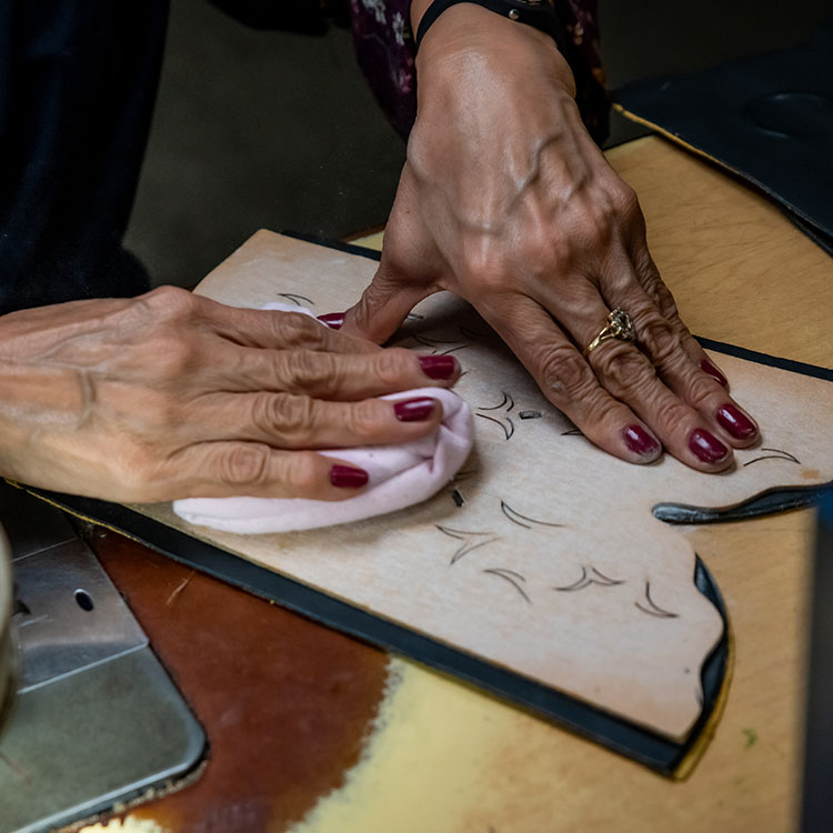 Women works on leather for boots
